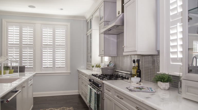 Plantation shutters in New York kitchen with modern appliances.